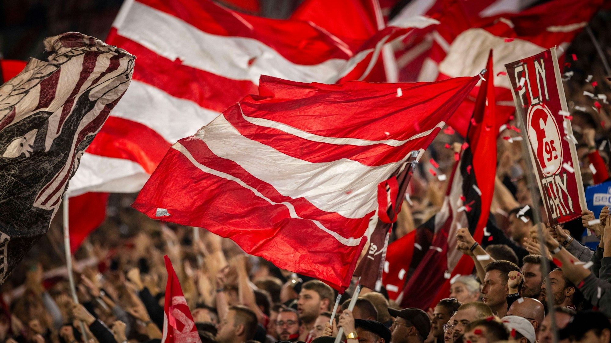 Fans von Fortuna Düsseldorf schwenken beim Heimspiel gegen den VfL Osnabrück ihre Fahnen.