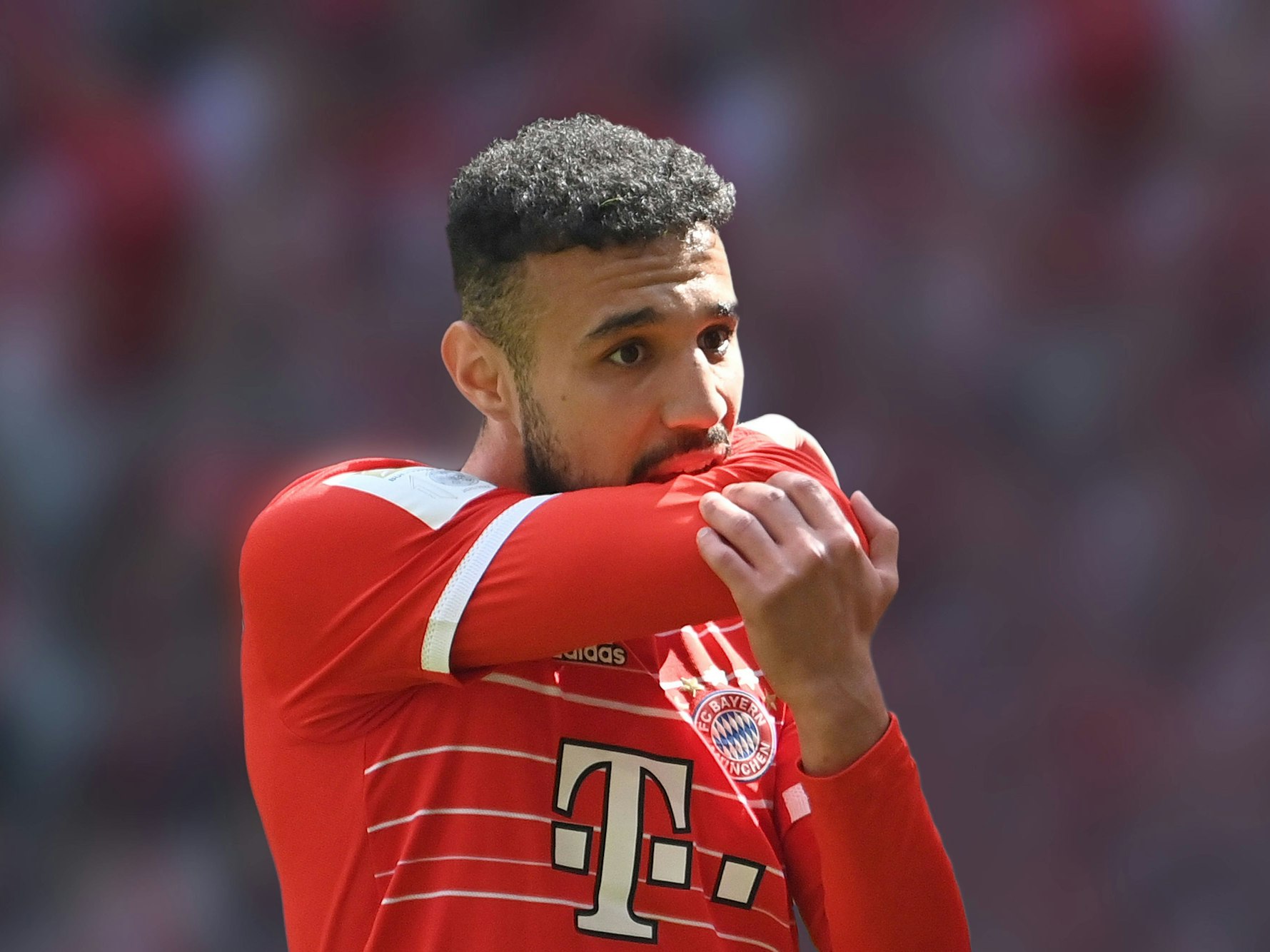 Noussair Mazraoui beißt sich im Bayern-Trikot in den Arm.