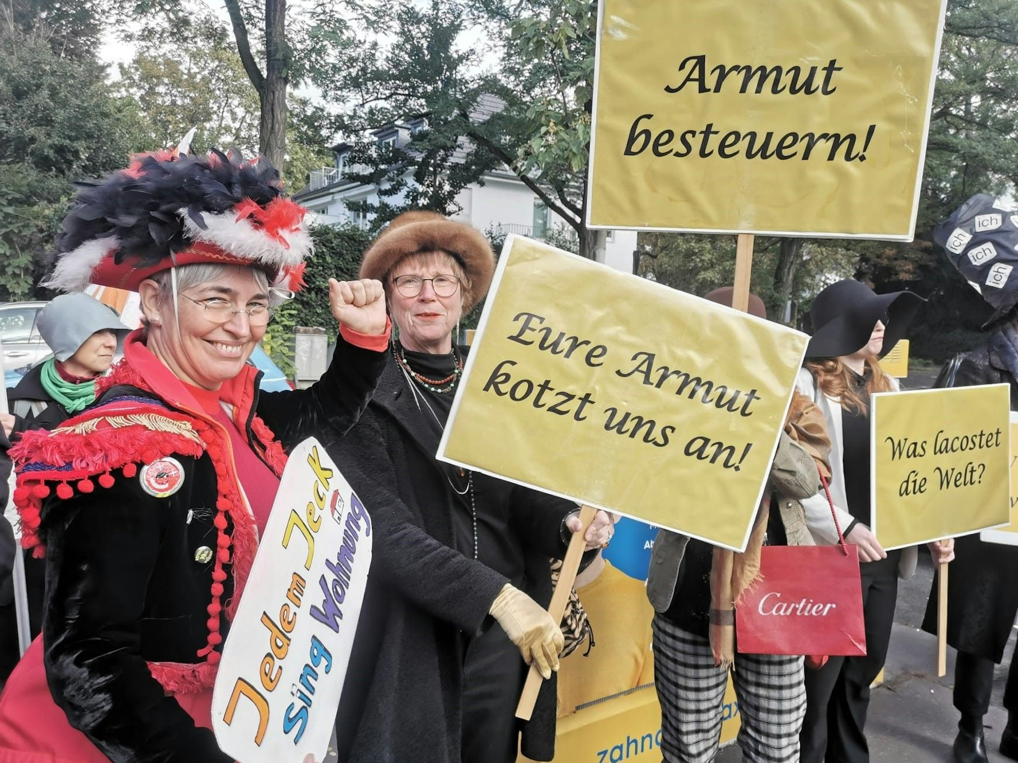 Mehrere Menschen halten Plakate hoch, darauf steht unter anderem „Eure Armut kotzt uns an“.