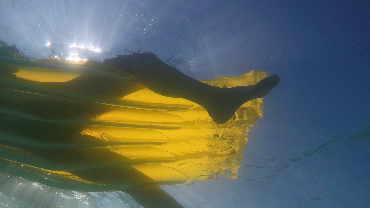 Ein Mensch schwebt im Meer auf Mallorca auf einer Luftmatratze.