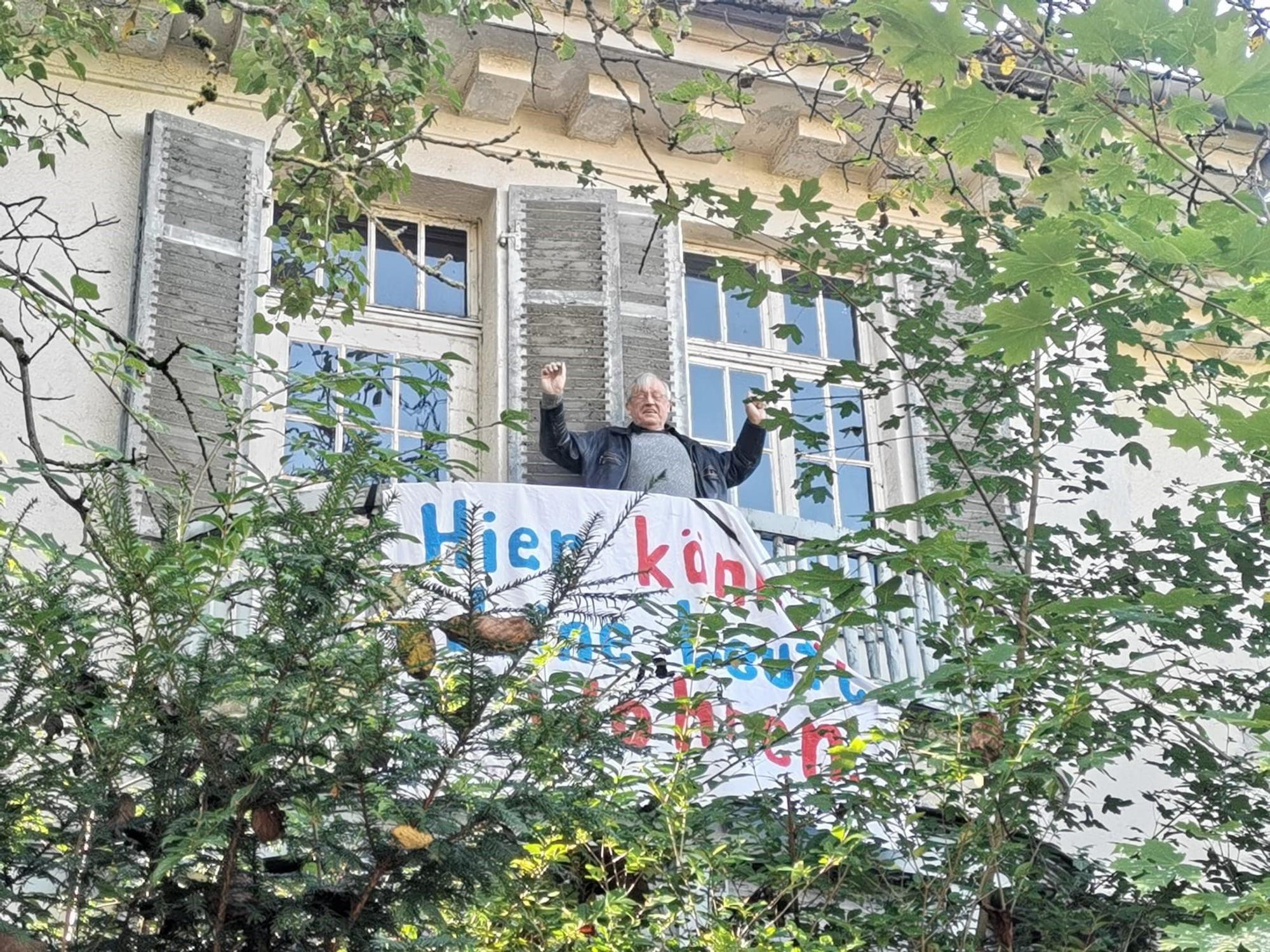 Ein Mann steht auf eine Balkon.