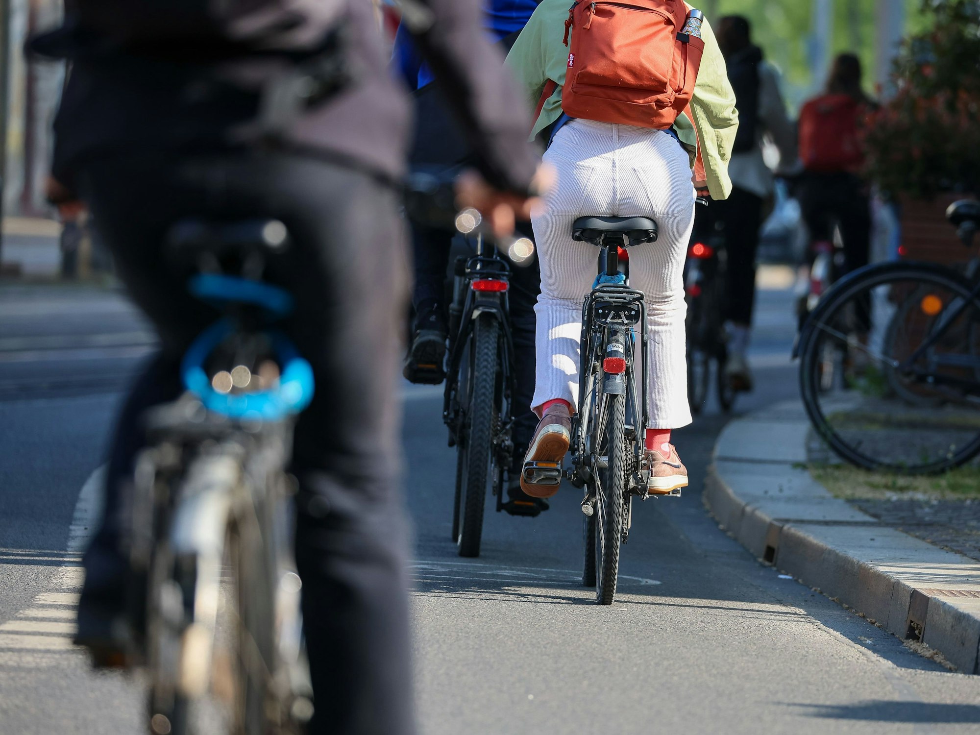 Mehrere Radfahrer und Radfahrerinnen fahren im Mai 2023 in Leipzig auf einem Radweg.