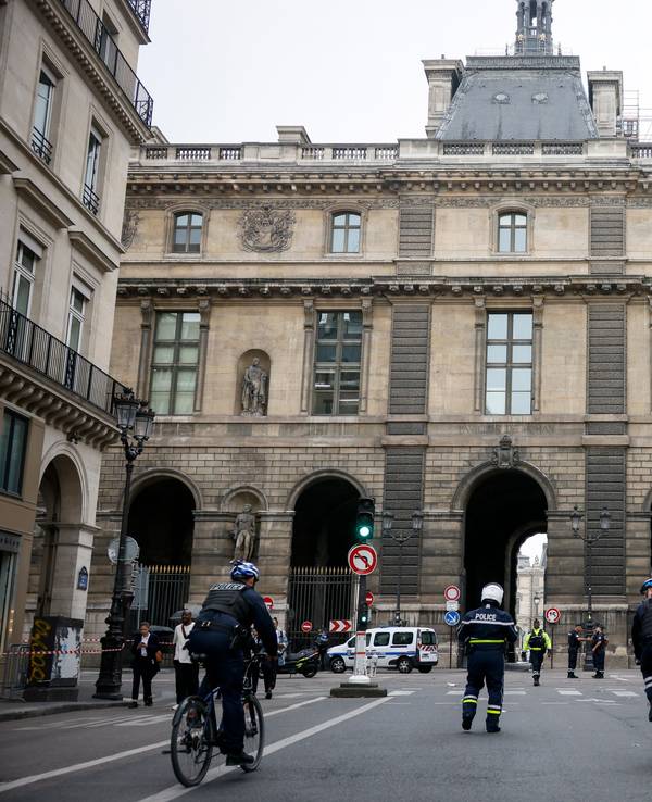Polizeibeamte stehen vor dem Louvre Wache, der wegen einer Bombendrohung geräumt worden.