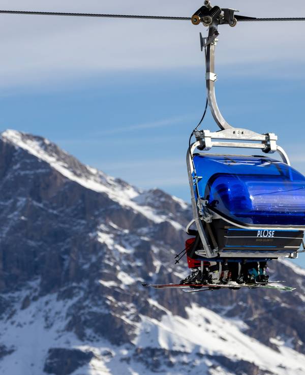Skifahrer lassen sich in einem Sessellift im Skigebiet Plose in den Lüsner Bergen in den Dolomiten auf den Berg bringen.