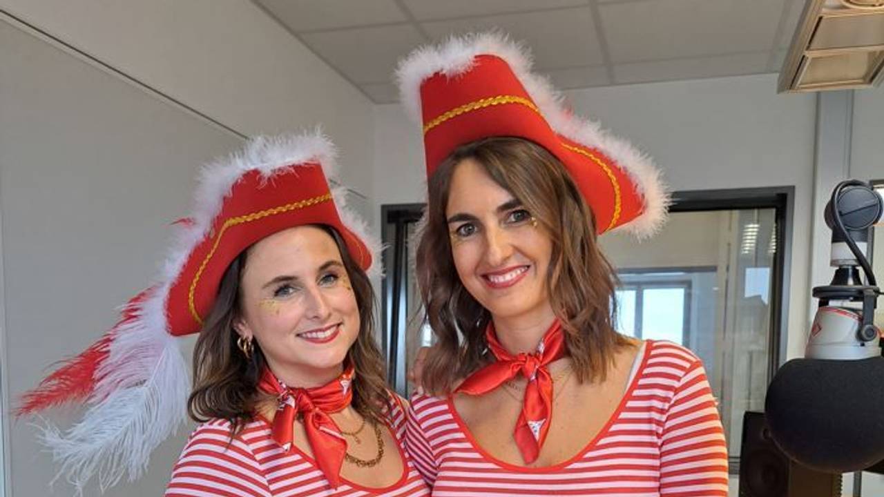 Zwei Frauen in rot-weißen Ringelshirts stehen in einem Studio und lächeln in die Kamera.