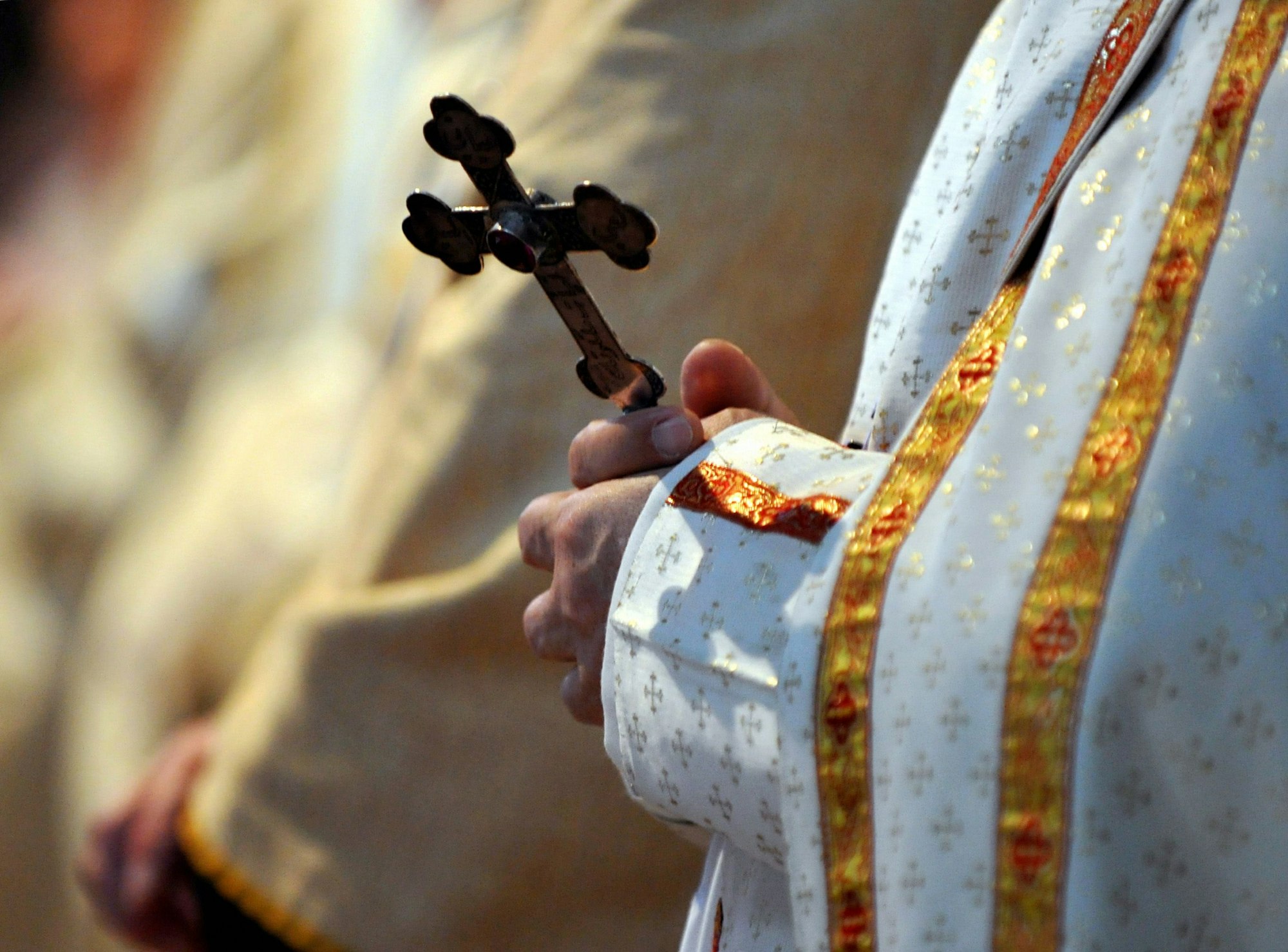 Ein Bischof hält während einer katholischen Messe in der Sankt Paul Kirche ein Kreuz in den Händen.