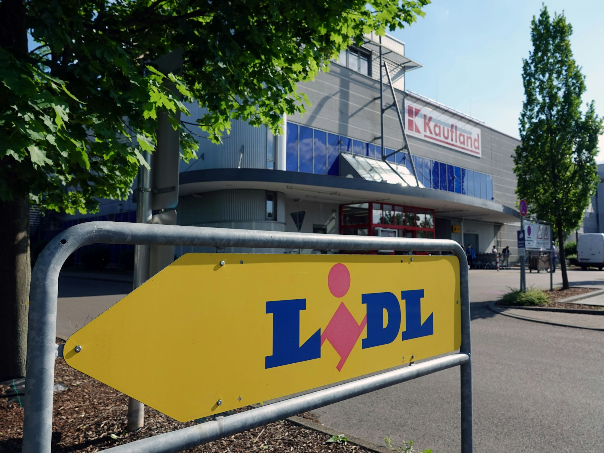 Ein Schild weist auf eine Filiale des Lebensmitteldiscounters Lidl hin. Im Hintergrund befindet sich eine Filiale des Großflächen-Discounters Kaufland.