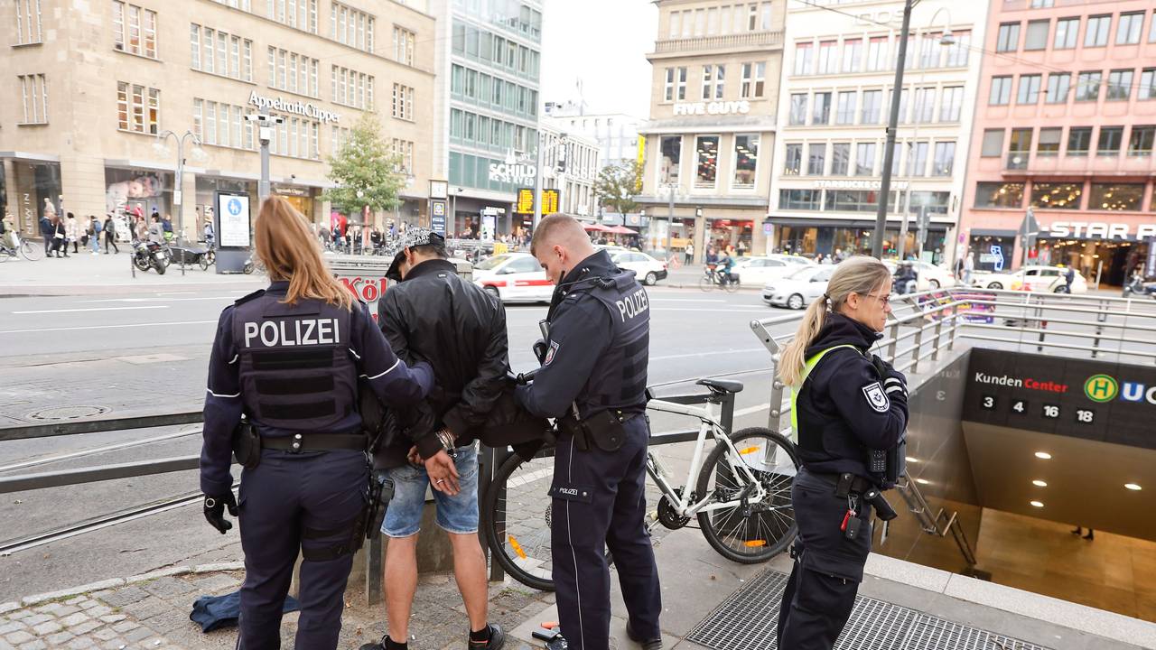 Einsatzkräfte der Polizei legen einem Mann am Neumarkt Handschellen an.