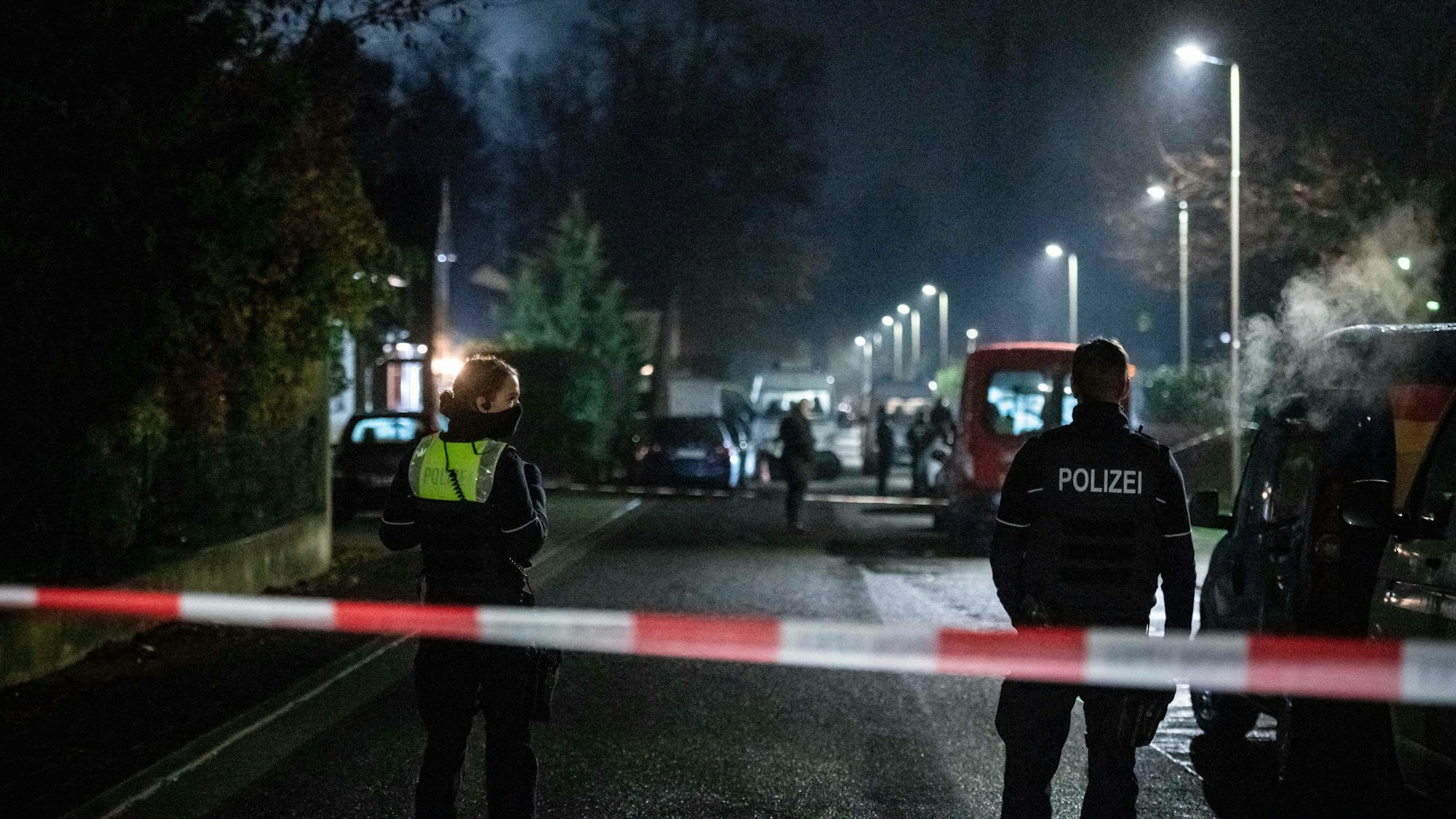Eine Polizistin und ein Polizist stehen an einem Absperrband.