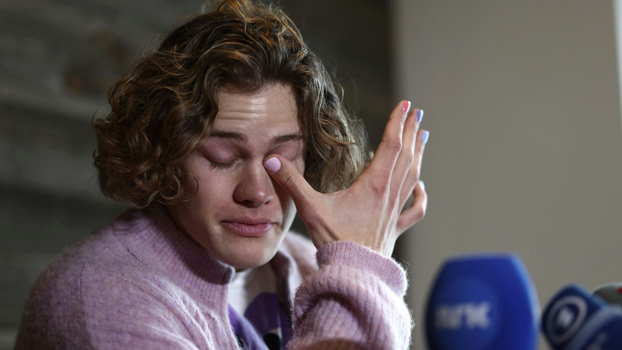Lucas Braathen wischt sich bei einer Pressekonferenz die Tränen aus den Augen.