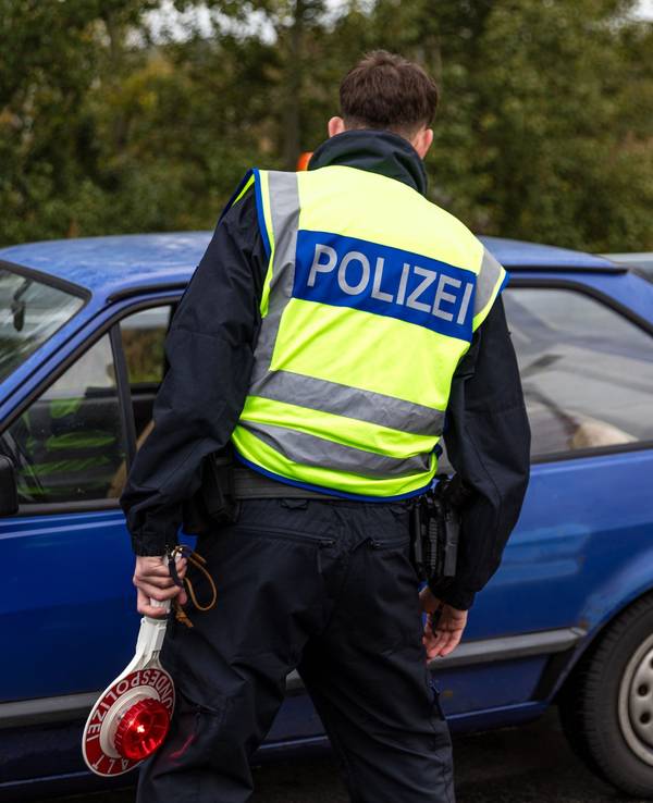 Ein Beamter der Bundespolizei spricht mit dem Fahrer eines Pkw an der Autobahn.