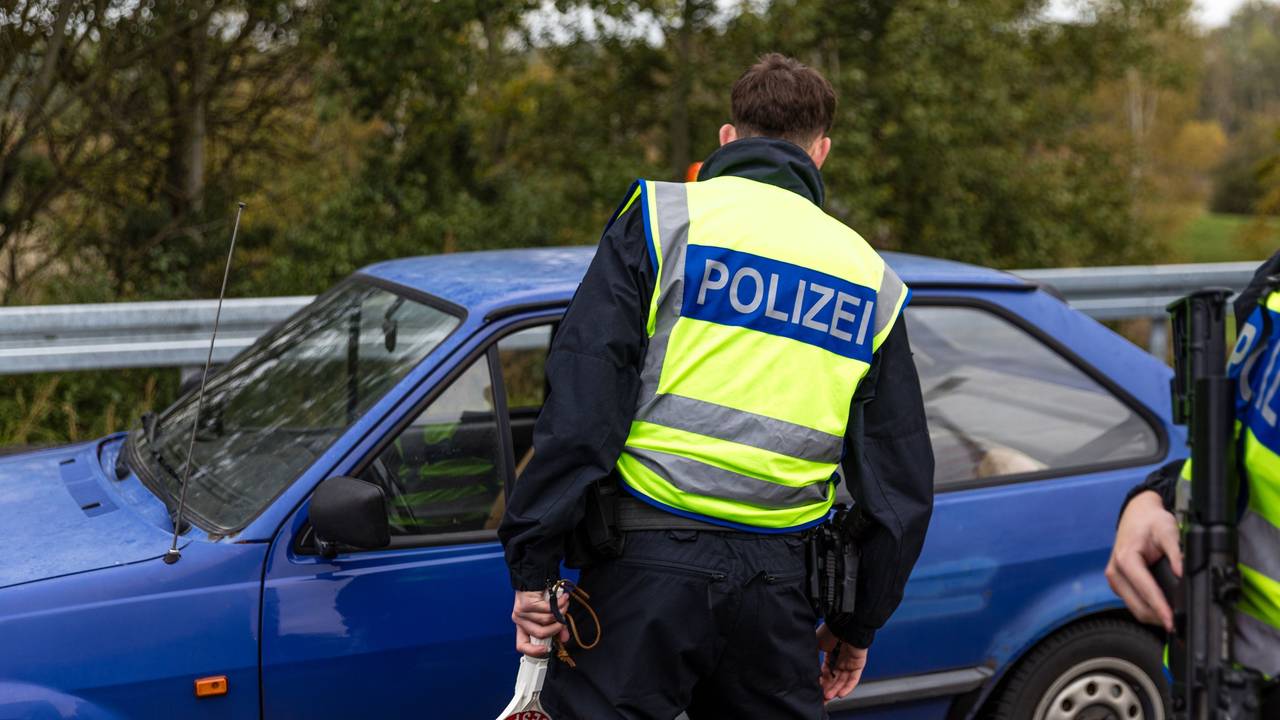 Ein Beamter der Bundespolizei spricht mit dem Fahrer eines Pkw an der Autobahn.