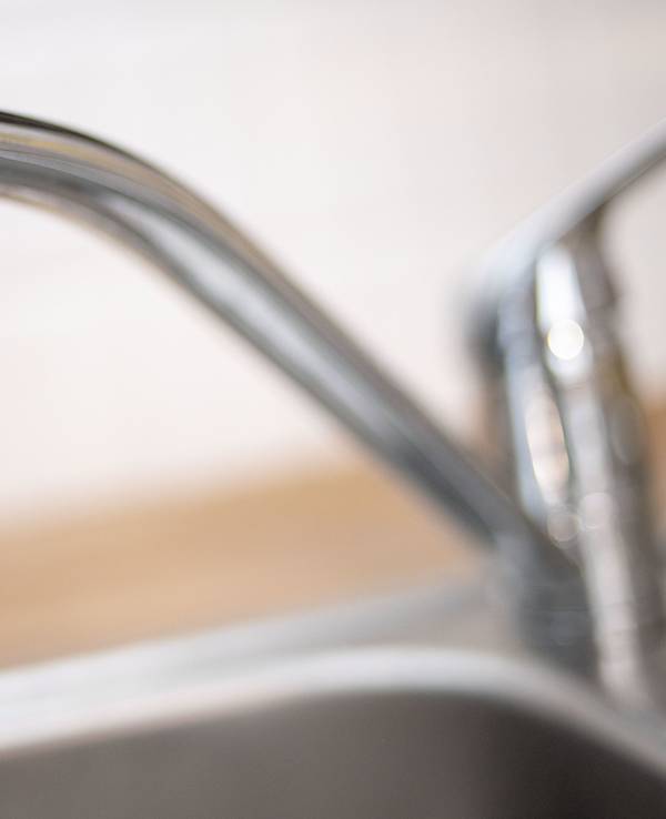Wasser läuft aus einem Wasserhahn an der Spüle.