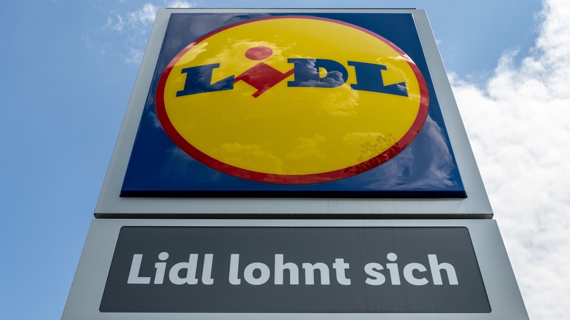 Eine Stele mit dem Logo des Discounters Lidl steht vor einer Filiale.