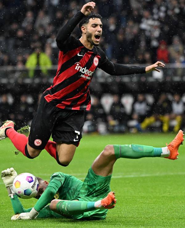 Omar Marmoush fällt über den herausstürmenden BVB-Torwart Alexander Meyer.