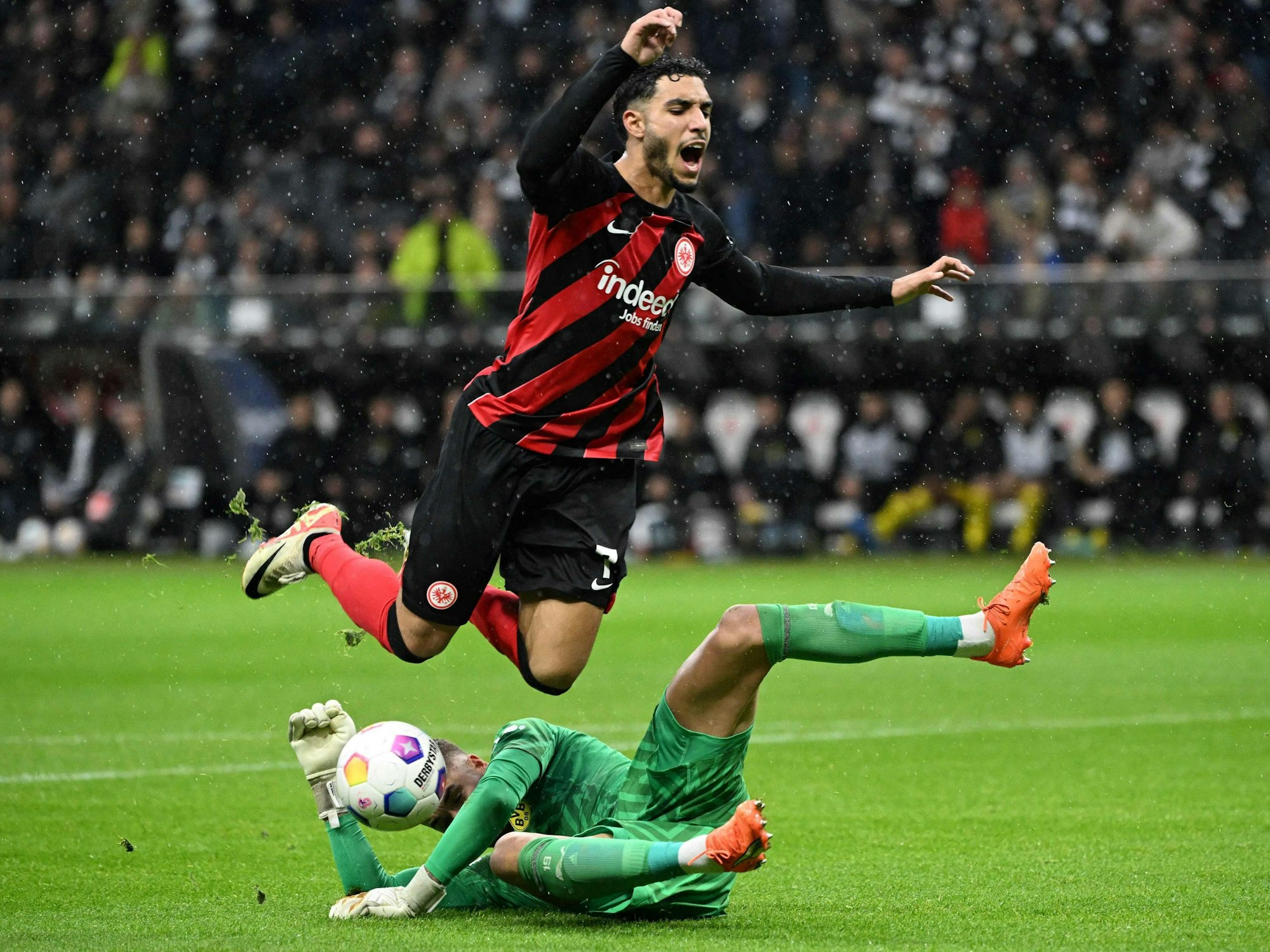 Omar Marmoush fällt über den herausstürmenden BVB-Torwart Alexander Meyer.