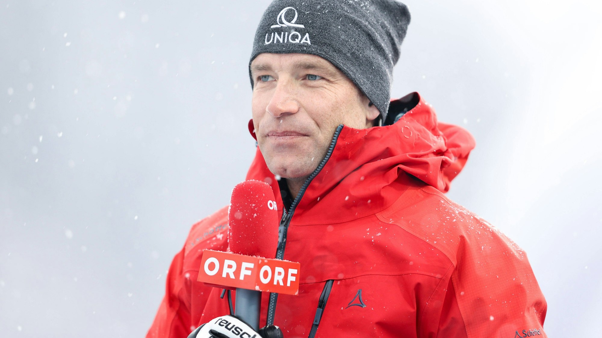 Benjamin Raich hält als TV-Experte ein ORF-Mikro in der Hand.