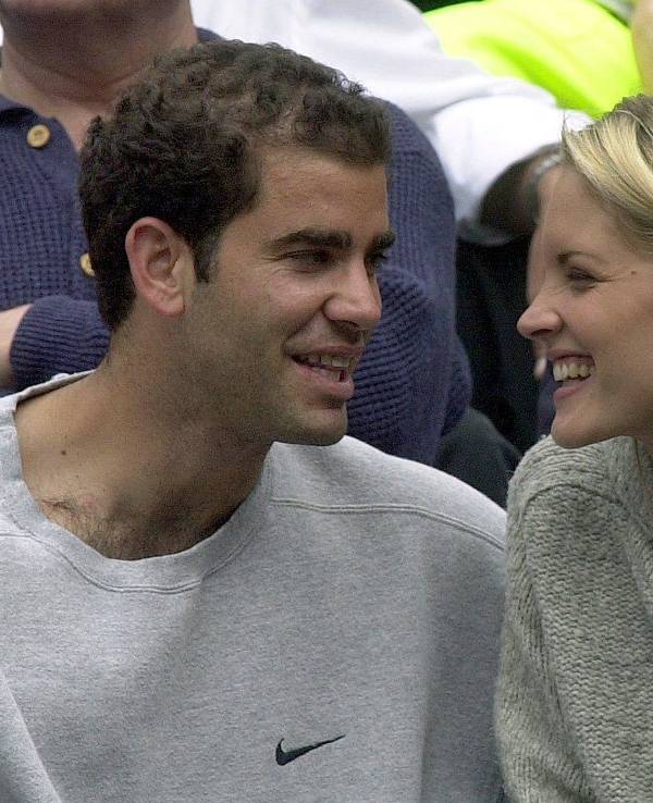 Der US-Amerikaner Pete Sampras lacht während des Spiels seines Teamkollegen mit seiner Begleiterin Brigitte Wilson.