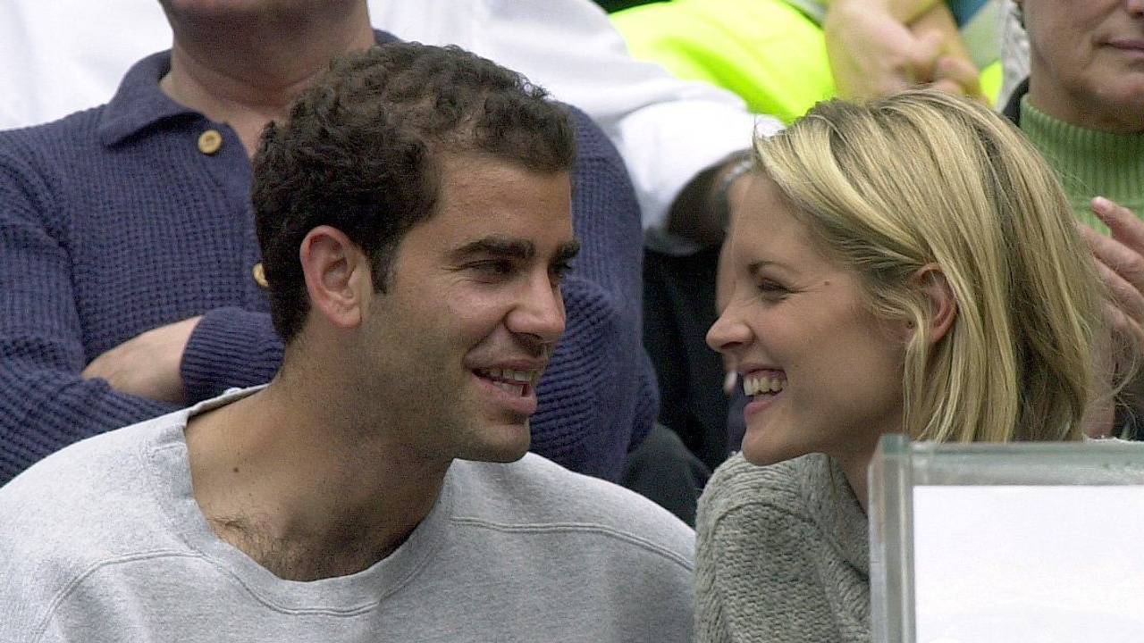 Der US-Amerikaner Pete Sampras lacht während des Spiels seines Teamkollegen mit seiner Begleiterin Brigitte Wilson.