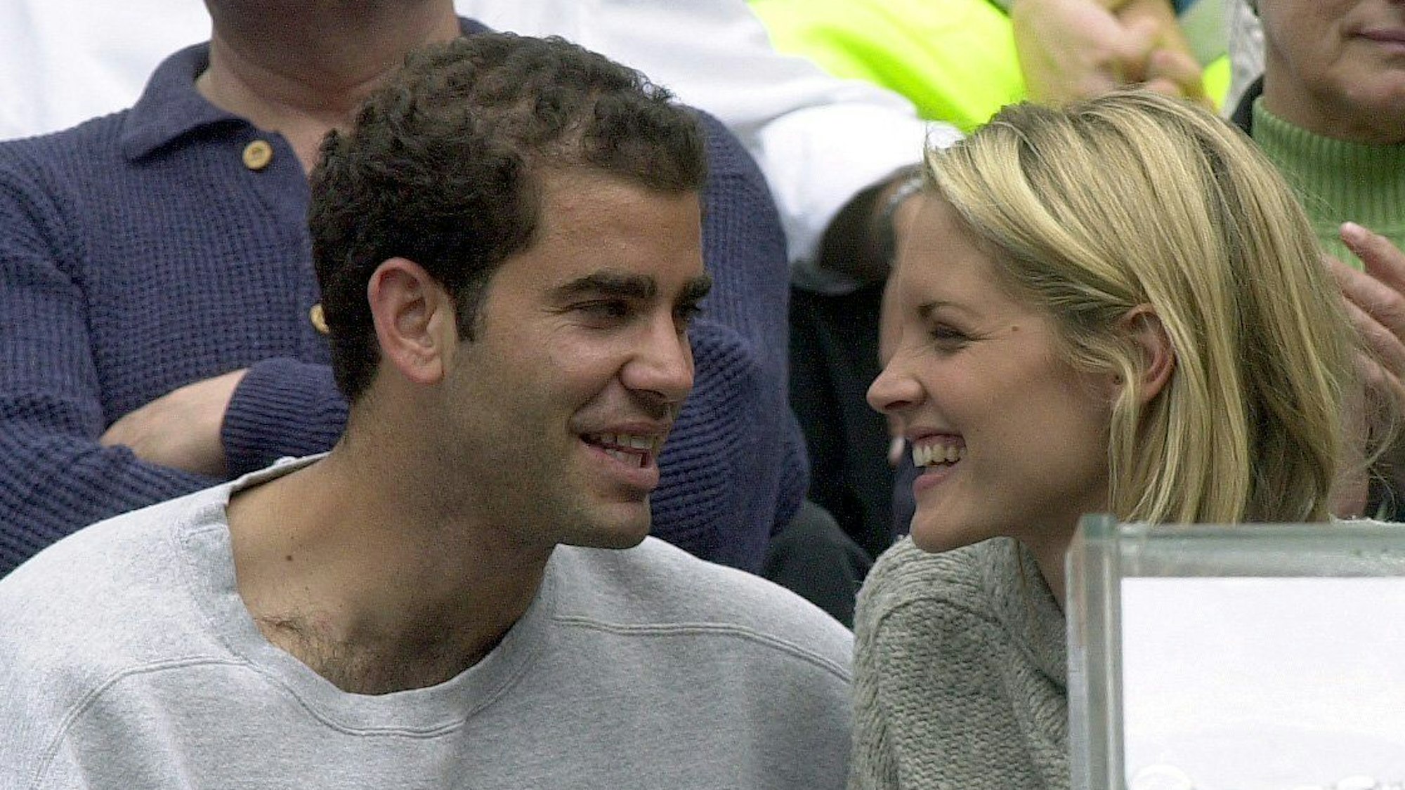 Der US-Amerikaner Pete Sampras lacht während des Spiels seines Teamkollegen mit seiner Begleiterin Brigitte Wilson.