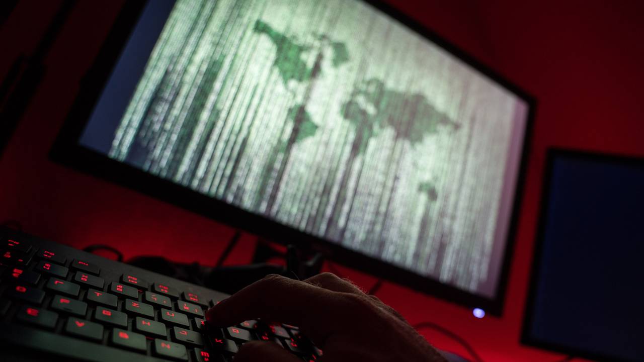 Ein Mann sitzt am Rechner und tippt auf einer Tastatur.