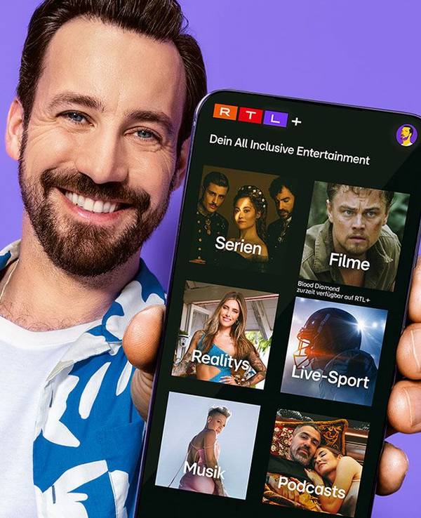 Mann hält Smartphone mit RTL+ App.