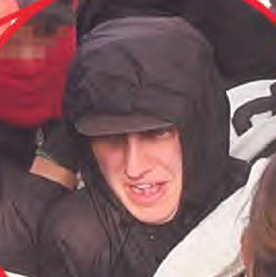 Mann mit schwarzer Jacke und Kapuze, nur ein Teil seines Gesichts ist zu erkennen.