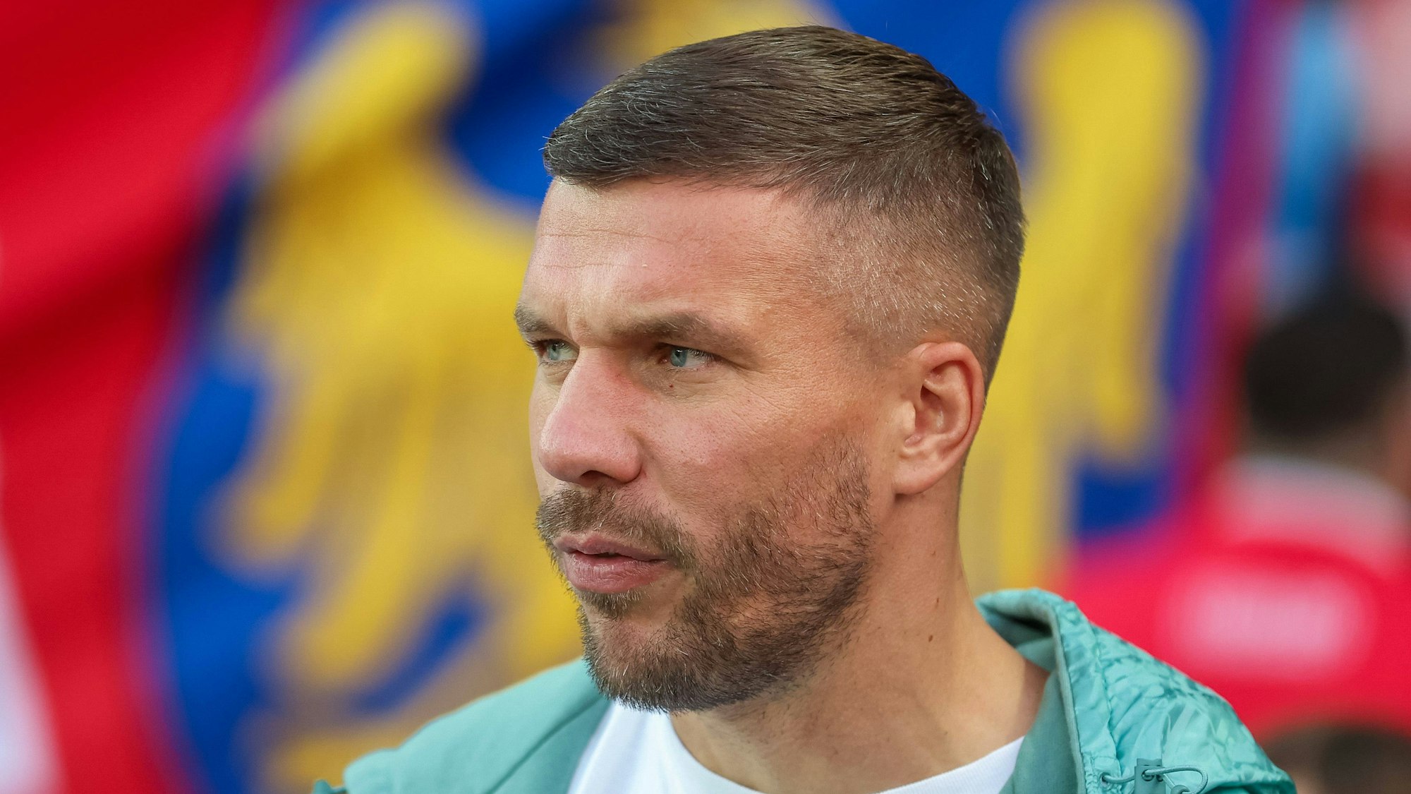 Lukas Podolski steht beim Spiel am Rande des Platzes.
