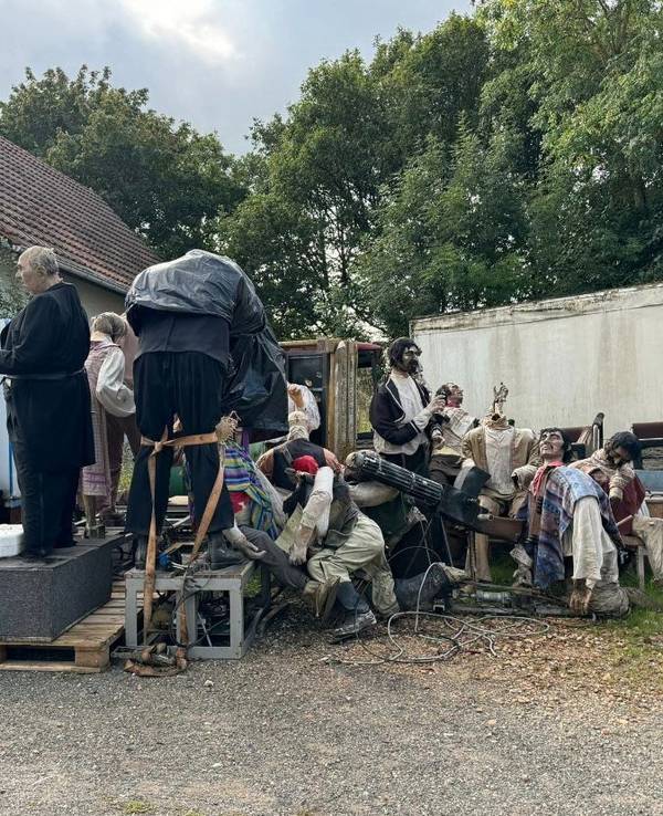 Diverse Figuren aus dem Phantasialand stehen wie auf einer Müllkippe in einem Hinterhof.