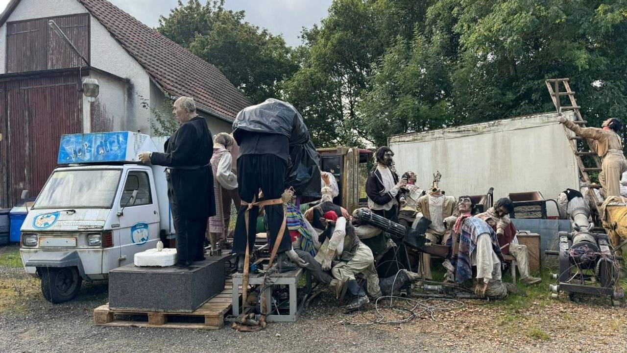 Diverse Figuren aus dem Phantasialand stehen wie auf einer Müllkippe in einem Hinterhof.