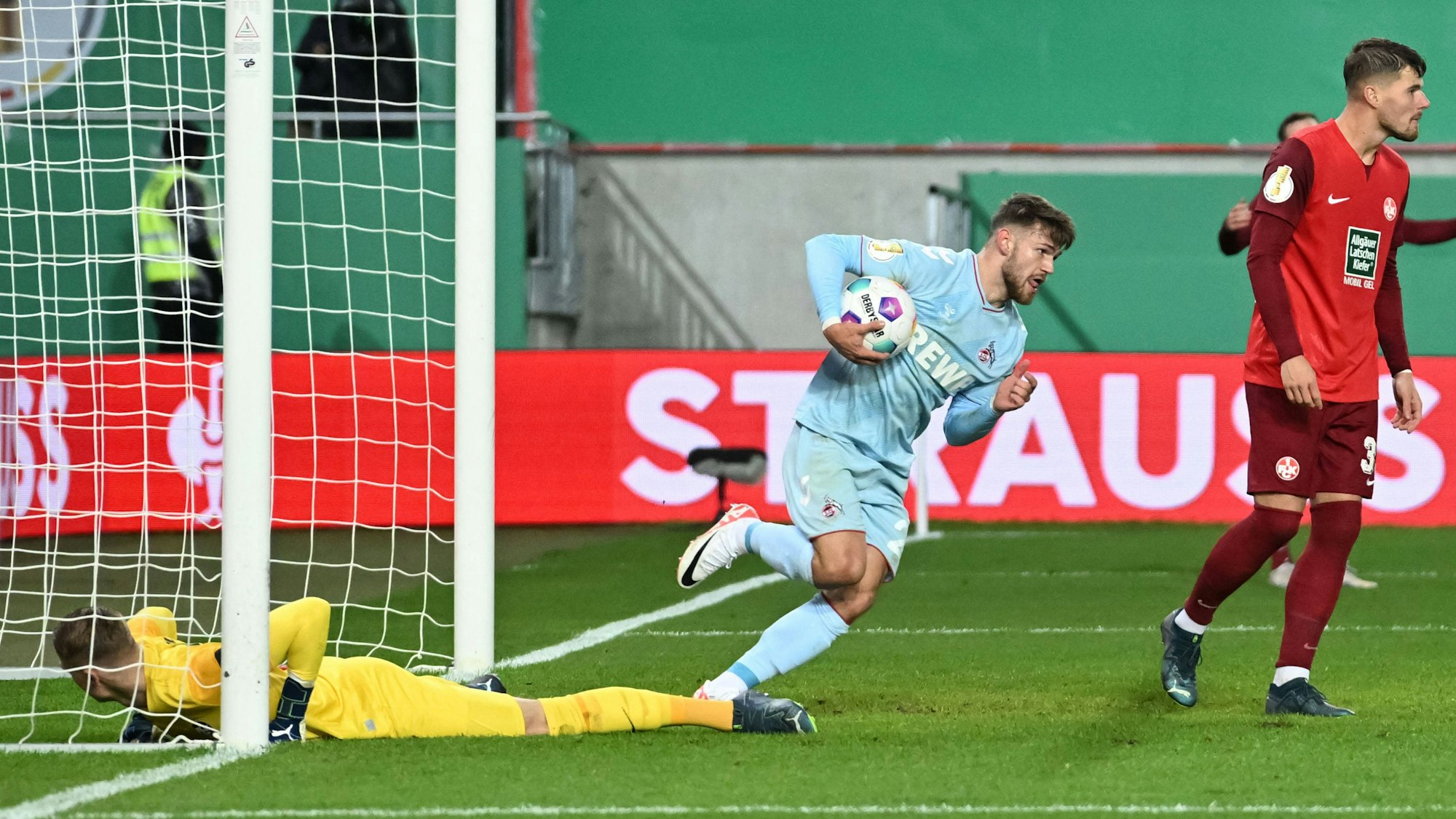 Jan Thielmann (1. FC Köln) beeilt sich und trägt den Ball nach dem Treffer zum Anstoßpunkt.