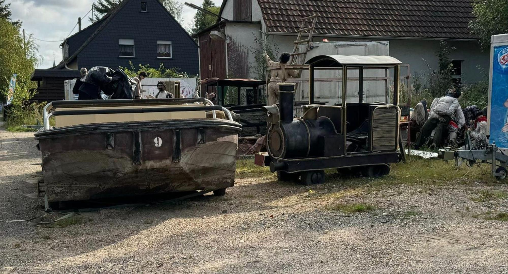 Alte Teile aus dem Phantasialand stehen und liegen auf einem großen Haufen in einem Hinterhof.