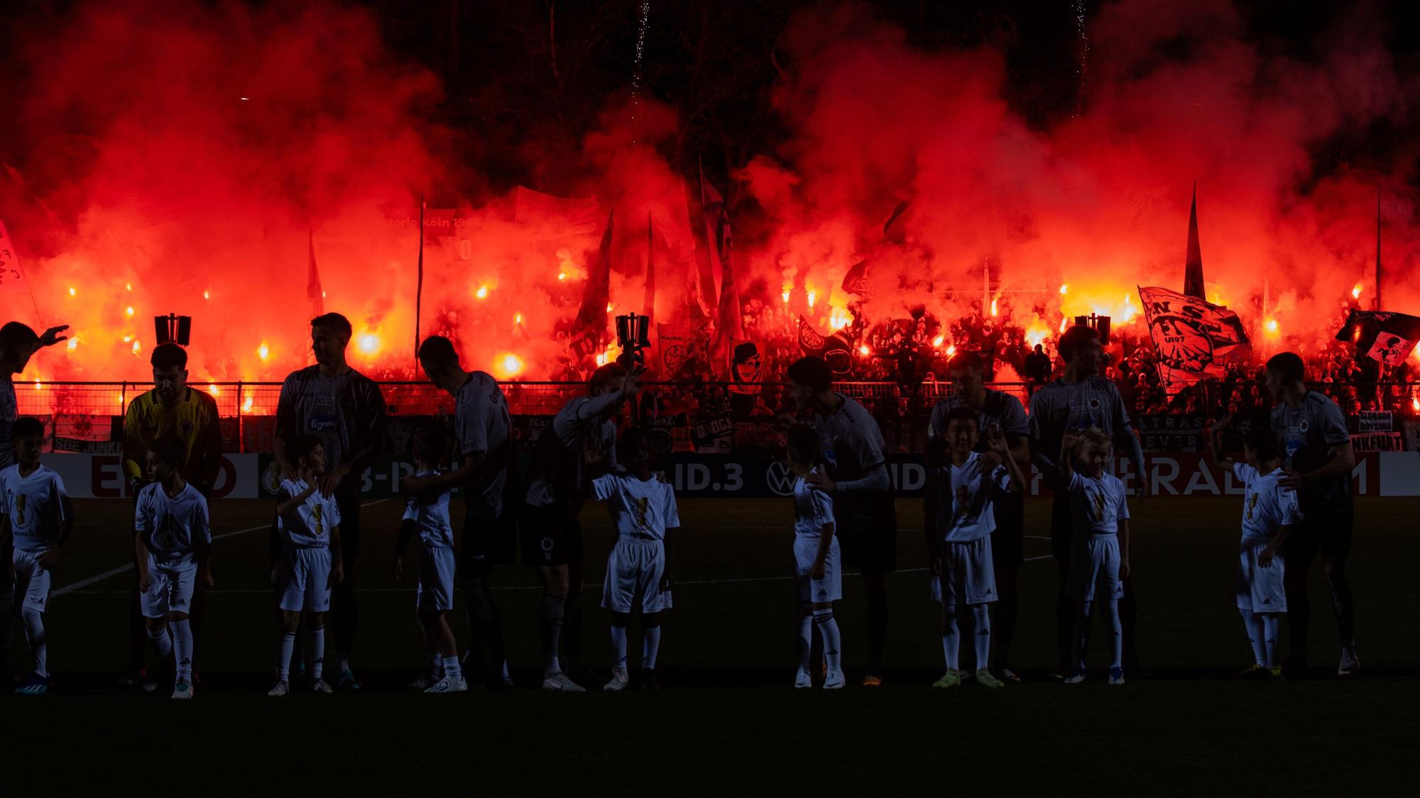 Die Fans von Eintracht Frankfurt zünden ein Feuerwerk vor dem Spiel im DFB-Pokal bei Viktoria Köln.