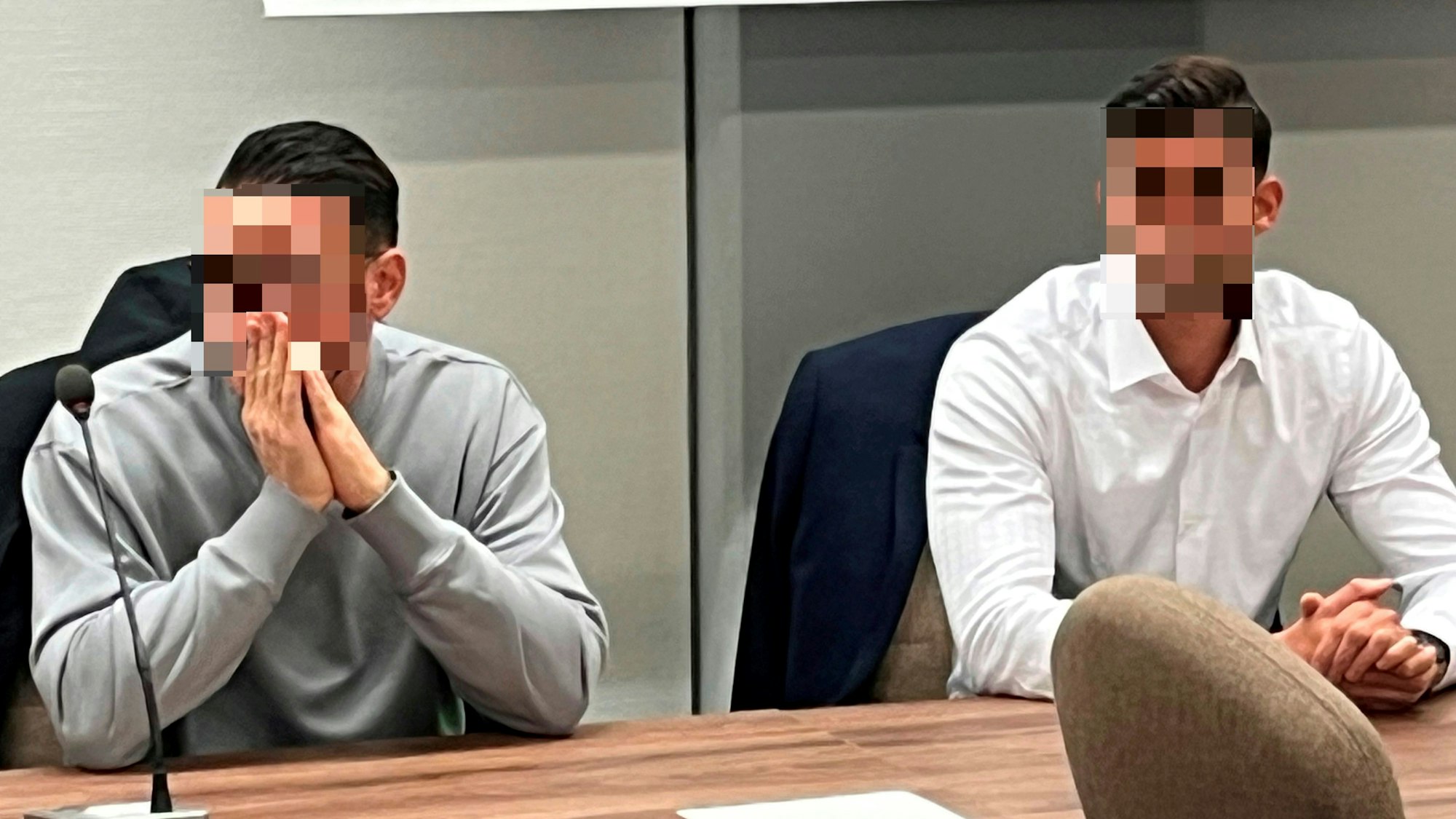 Zwei junge Männer sitzen auf der Anklagebank.