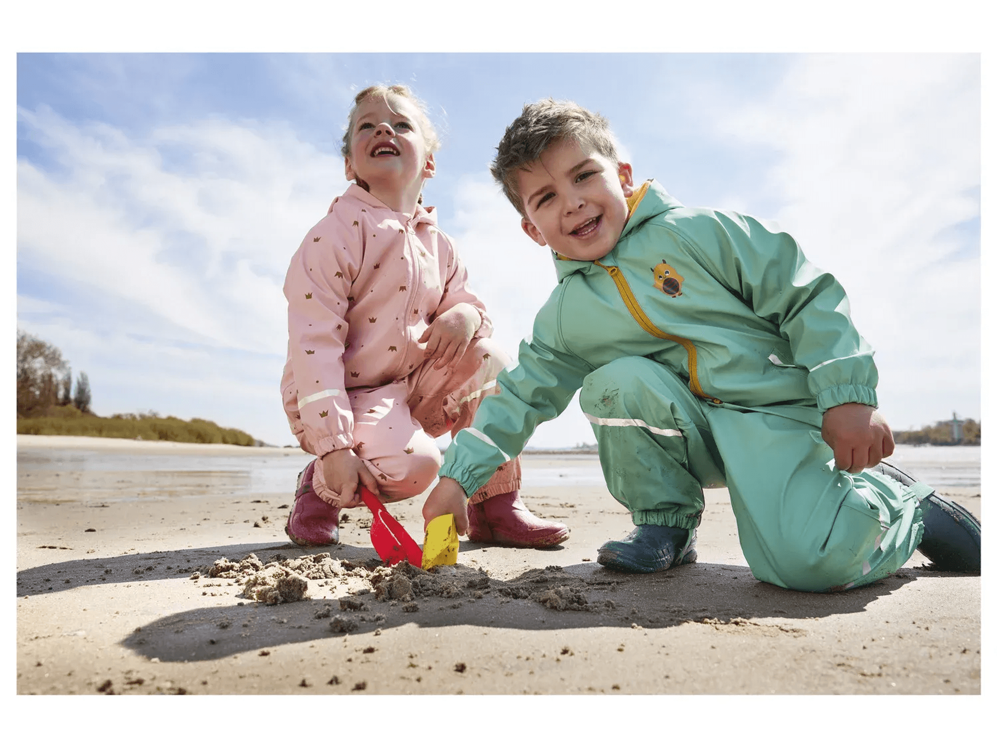 Auf dem Bild sind zwei Kinder zu sehen, die in Buddelsachen stecken.