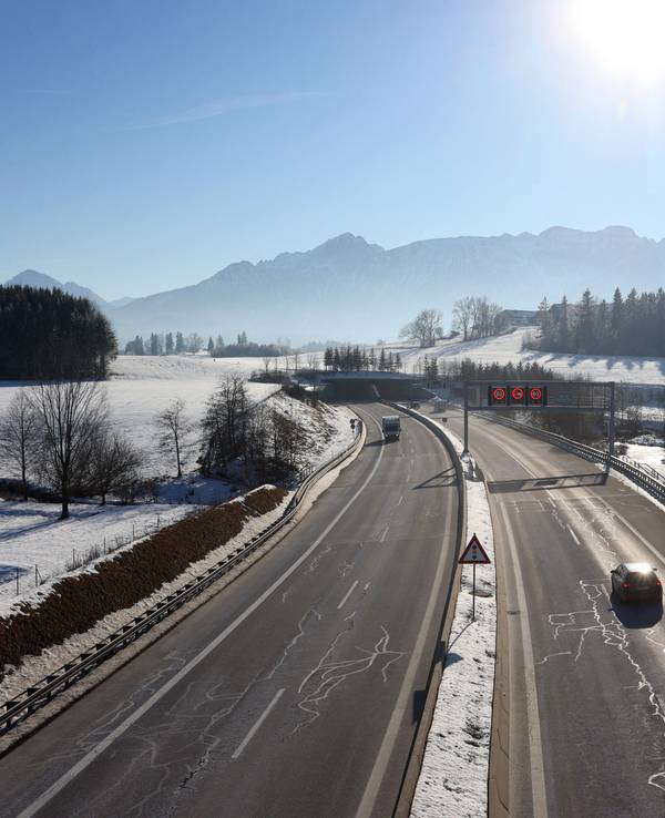 Ein Auto fährt im Winter auf einer Autobahn.
