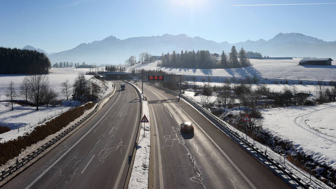 Ein Auto fährt im Winter auf einer Autobahn.