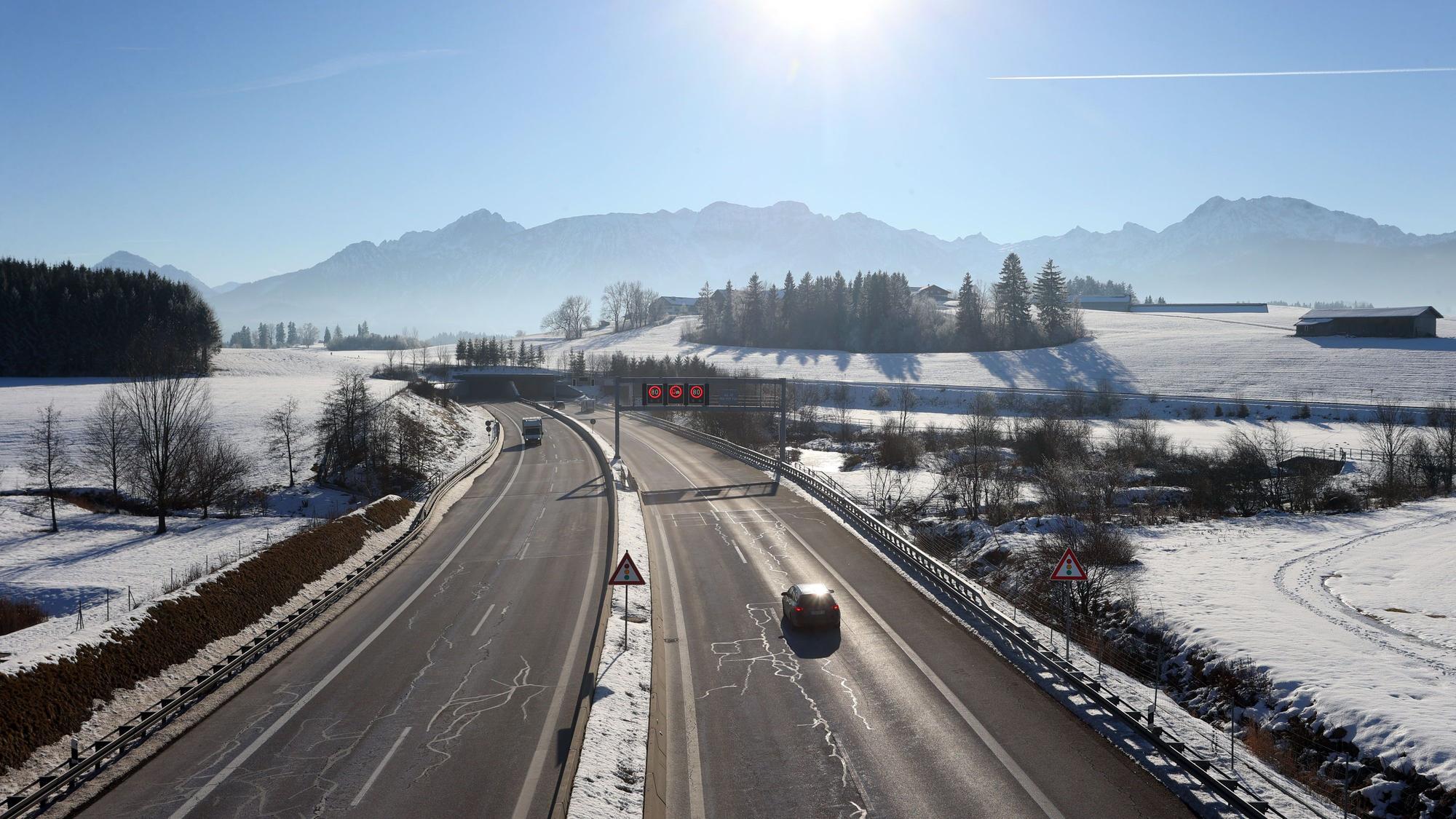 Ein Auto fährt im Winter auf einer Autobahn.