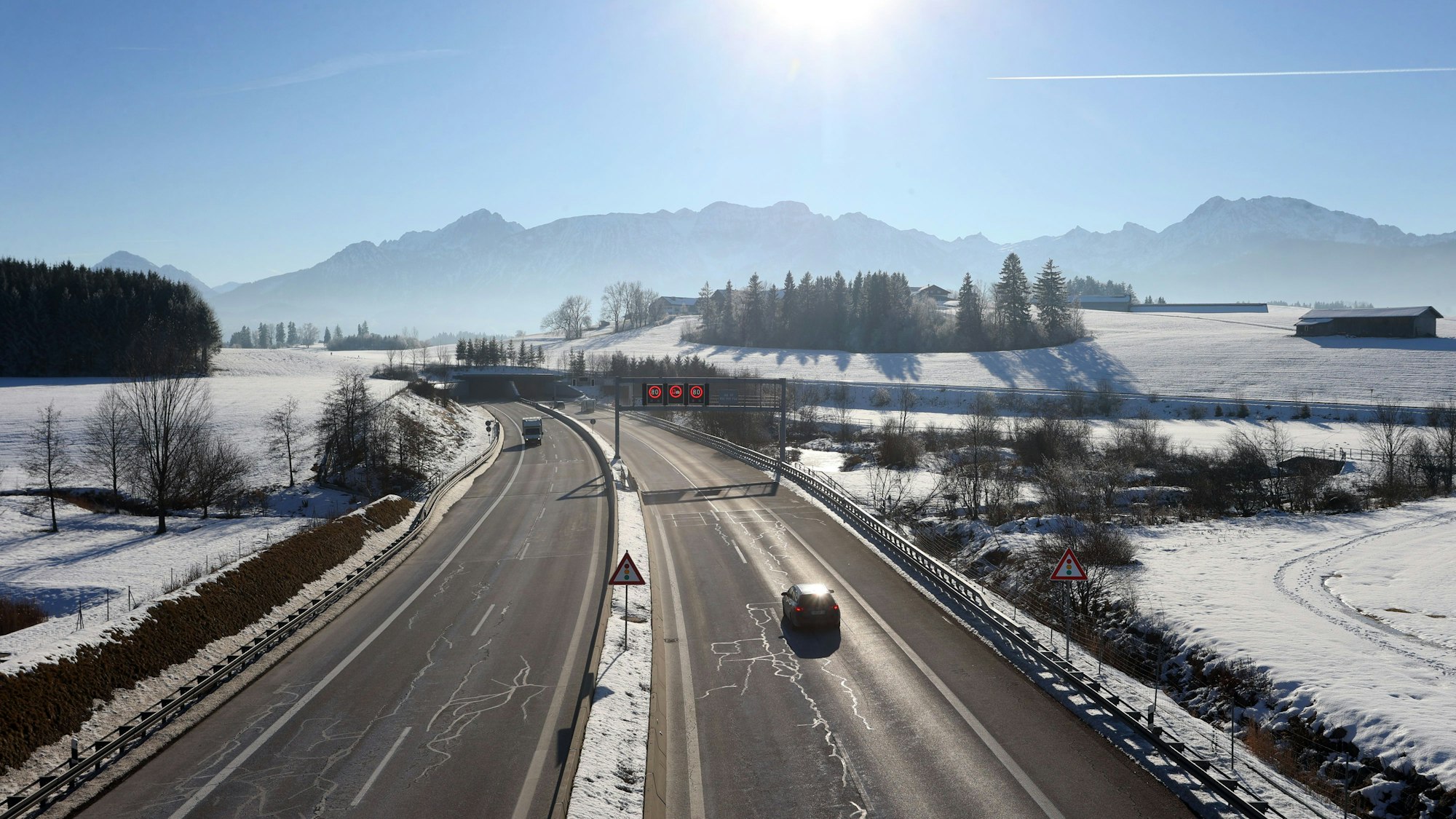 Ein Auto fährt im Winter auf einer Autobahn.
