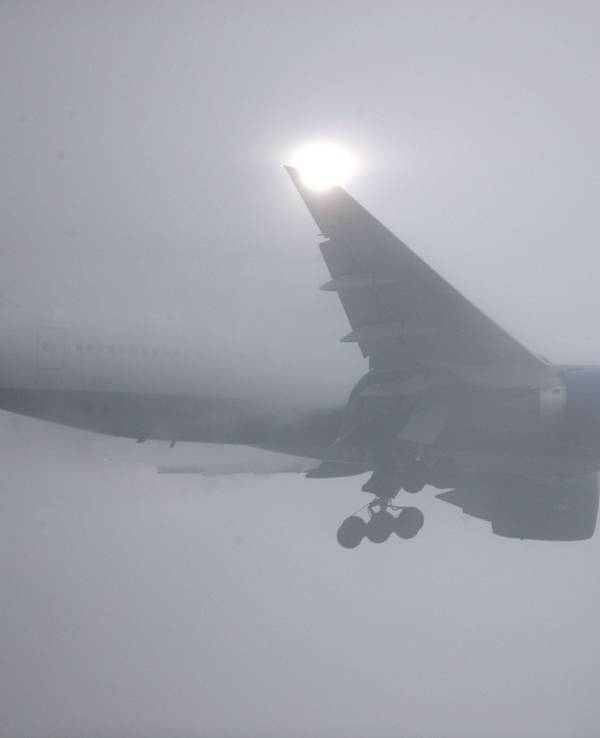 Unser Foto zeigt eine Maschine von British Airways bei Nebel über dem Flughafen Heathrow bei London.