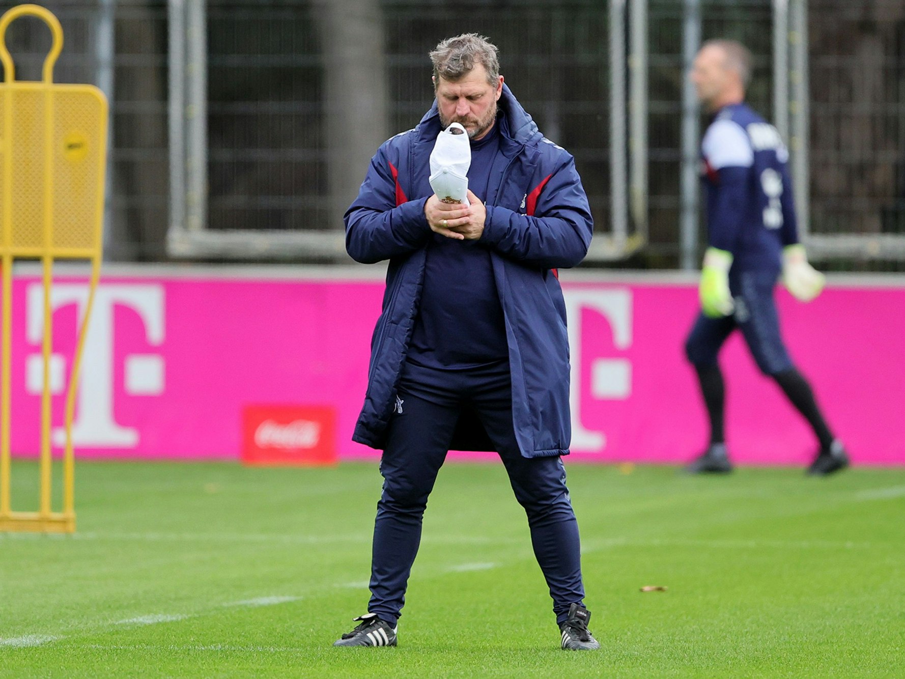 Steffen Baumgart schaut in seine Kappe.