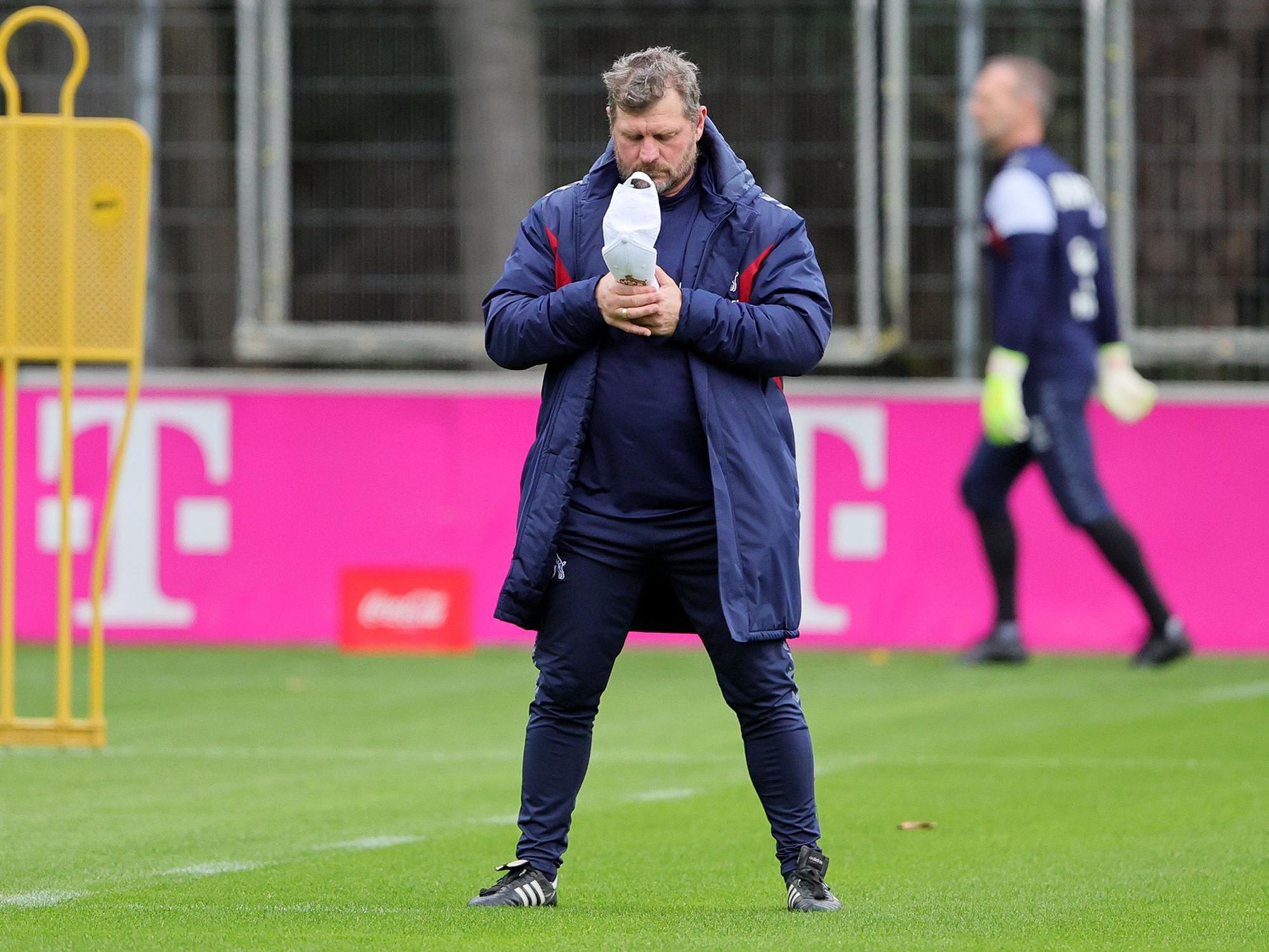 Steffen Baumgart schaut in seine Kappe.