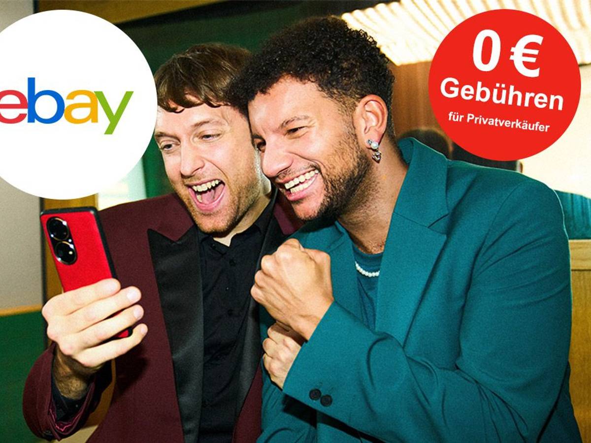 Zwei junge Männer jubeln, während sie auf das Smartphone blicken. Ebay Logo auf Bild.
