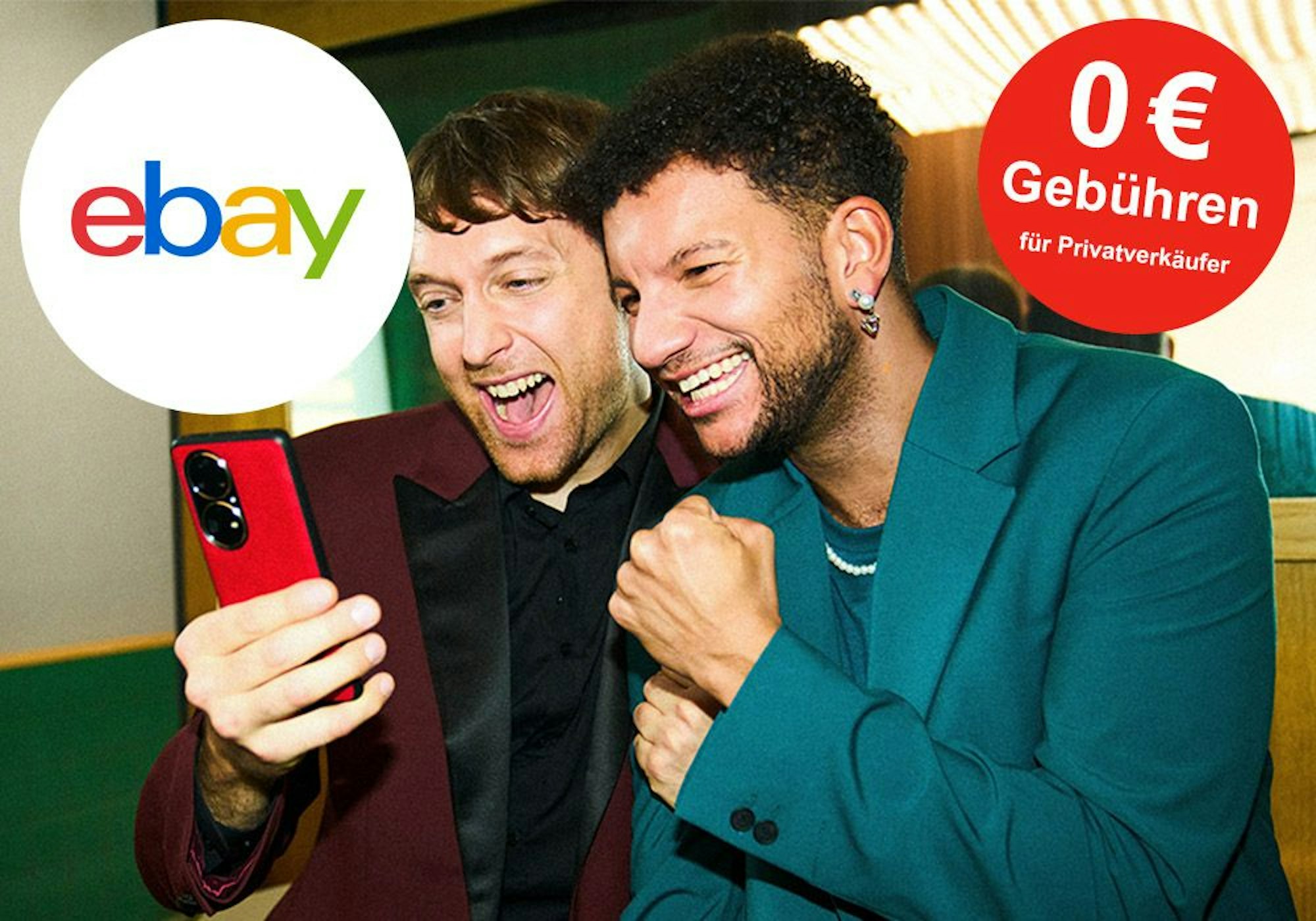 Zwei junge Männer jubeln, während sie auf das Smartphone blicken. Ebay Logo auf Bild.