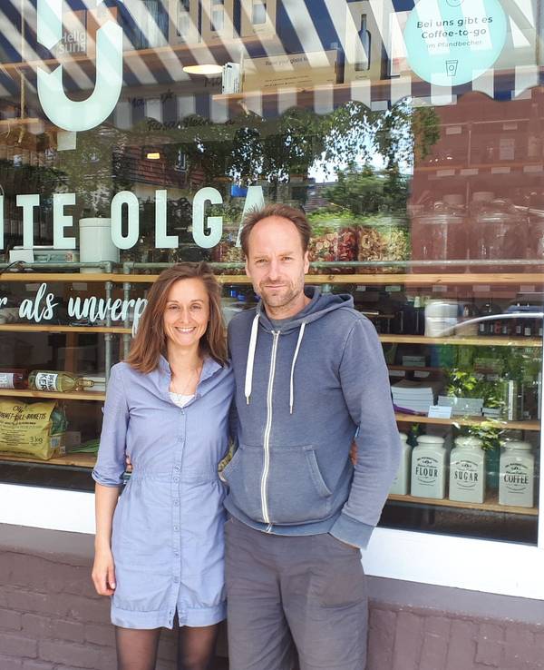 Olga und Gregor Witt vor ihrem Laden in Köln-Sülz, sie stehen Arm in Arm vor dem Schaufenster.