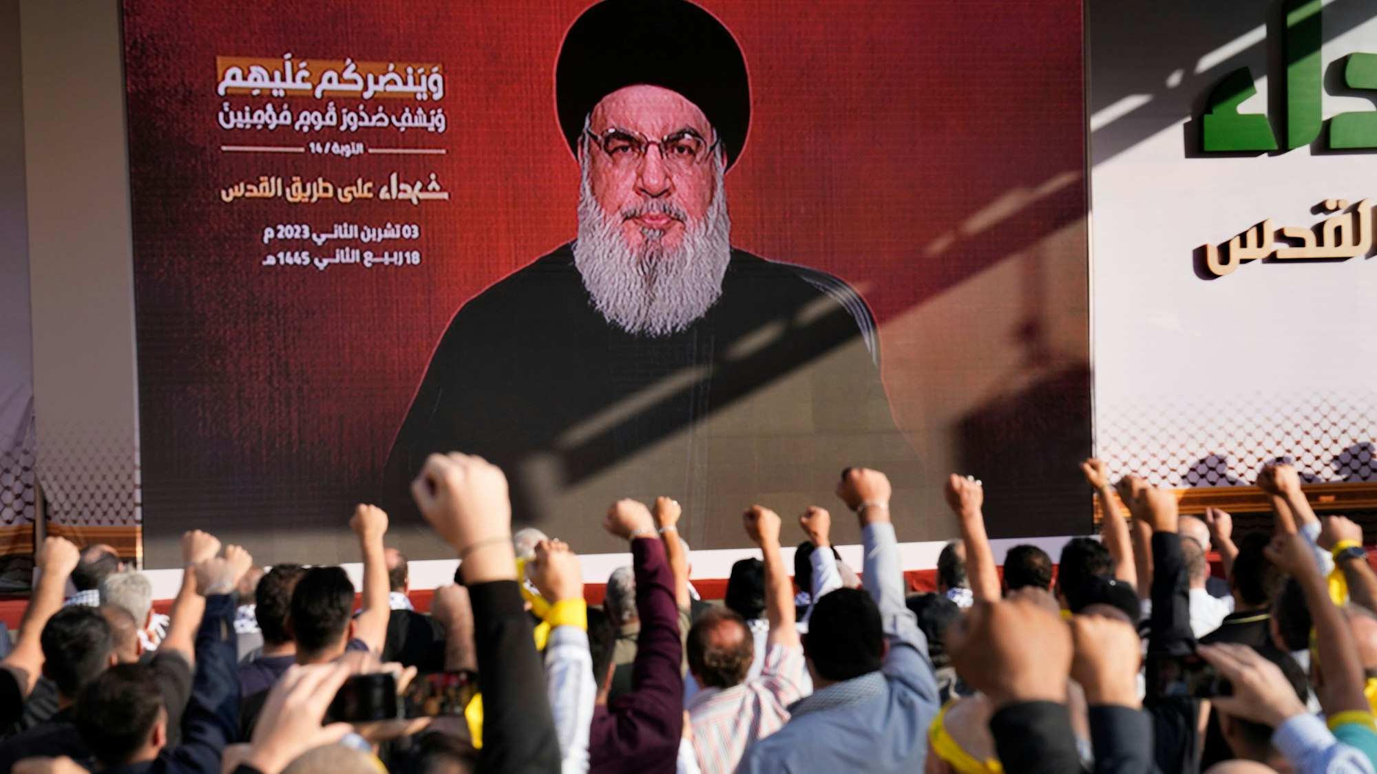 Anhänger der vom Iran unterstützten Hisbollah erheben ihre Fäuste und jubeln, als Hisbollah-Führer Hassan Nasrallah während einer Kundgebung zum Gedenken an Hisbollah-Kämpfer spricht.