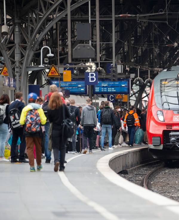 Bahhnreisende warten auf dem Bahnsteig auf die Einfahrt des Zuges im Kölner Hauptbahnhof.