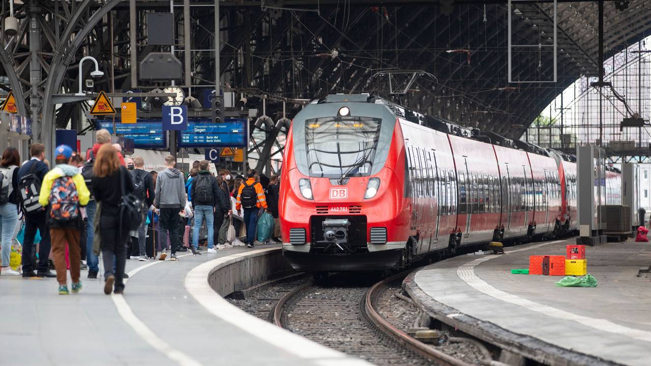 Bahhnreisende warten auf dem Bahnsteig auf die Einfahrt des Zuges im Kölner Hauptbahnhof.
