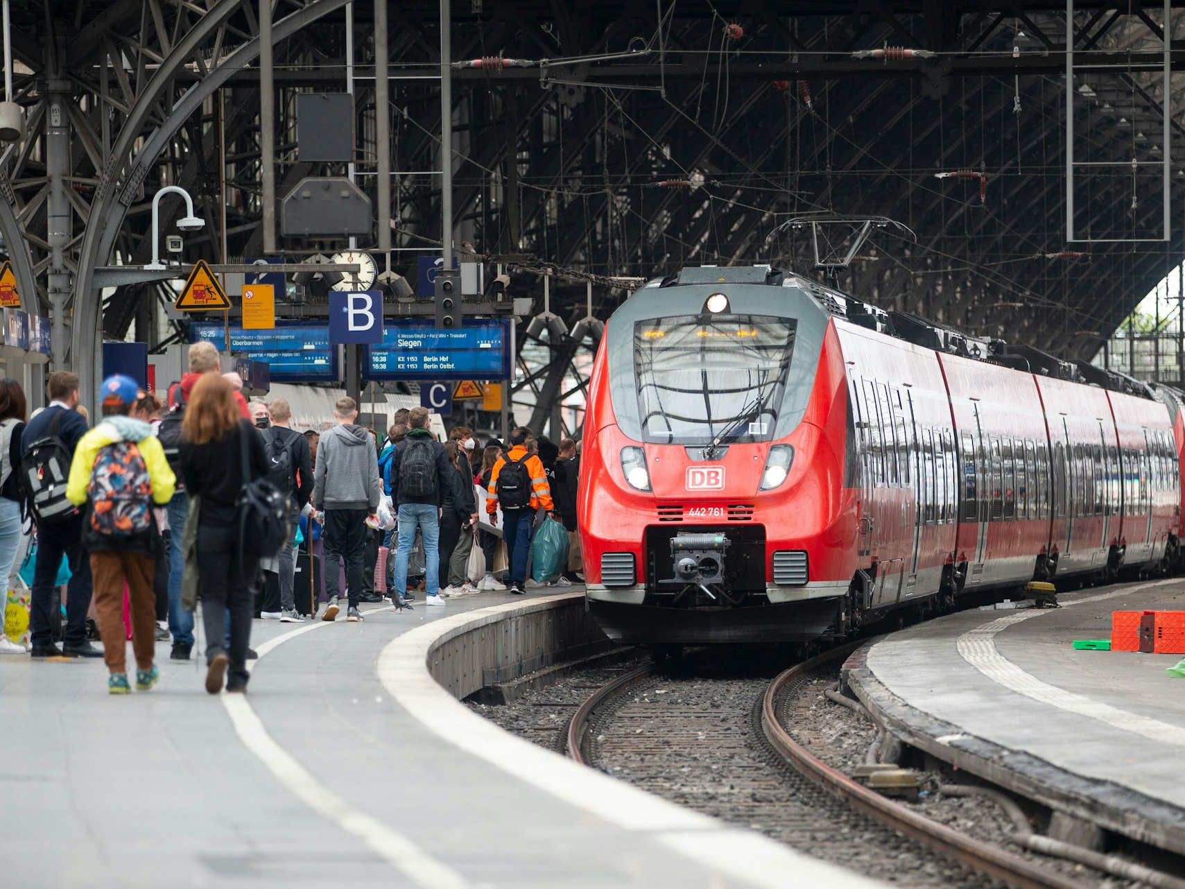 Bahhnreisende warten auf dem Bahnsteig auf die Einfahrt des Zuges im Kölner Hauptbahnhof.