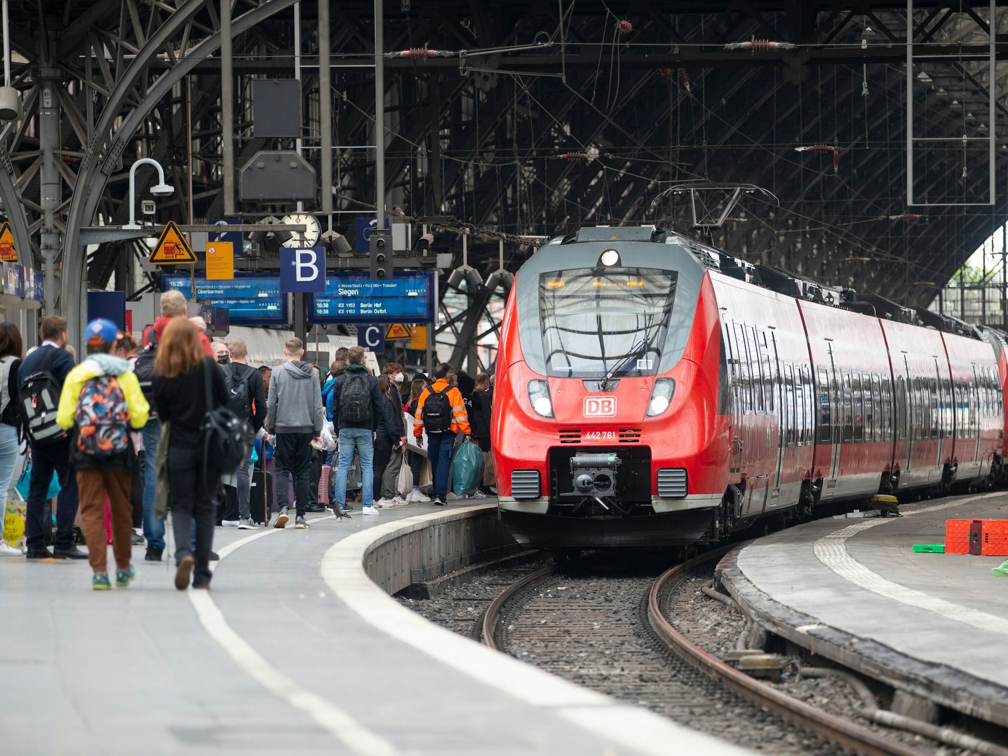 Bahhnreisende warten auf dem Bahnsteig auf die Einfahrt des Zuges im Kölner Hauptbahnhof.